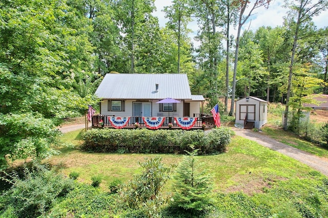 view of front of house featuring a front lawn and a shed