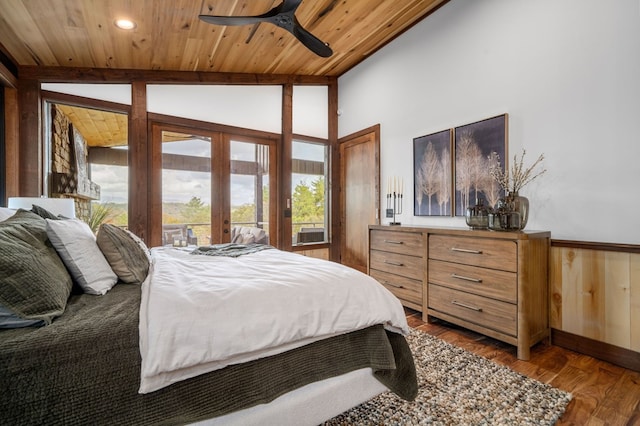 bedroom featuring lofted ceiling, wainscoting, wooden ceiling, french doors, and dark wood-style flooring