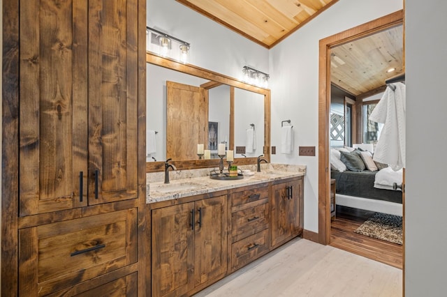 full bath featuring a sink, wood finished floors, connected bathroom, wooden ceiling, and lofted ceiling