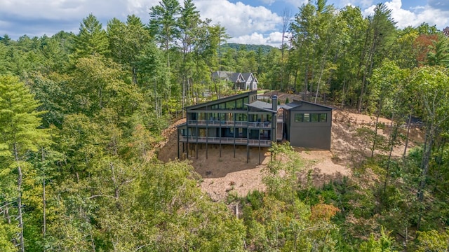 back of house featuring a wooded view