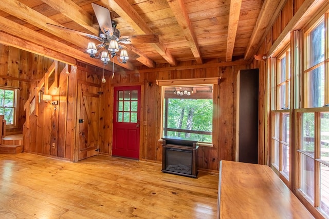 entrance foyer with beamed ceiling, a healthy amount of sunlight, wood ceiling, and wood walls