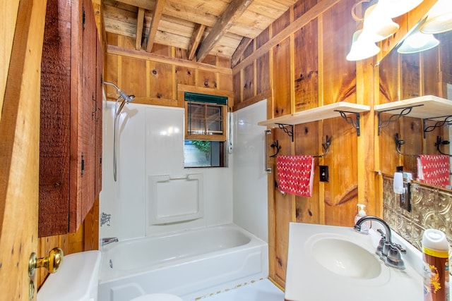 bathroom with wooden walls, tub / shower combination, and sink