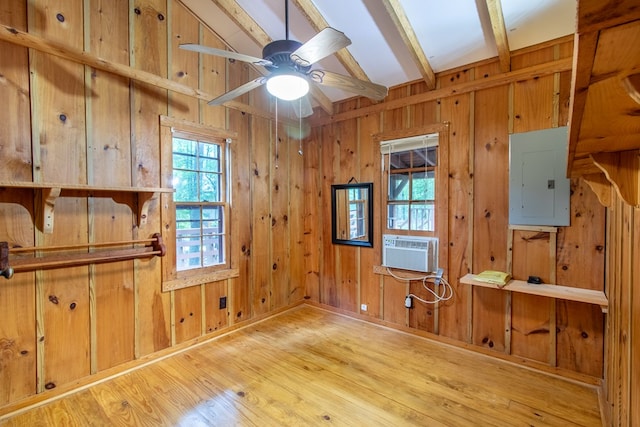 spare room with ceiling fan, electric panel, light hardwood / wood-style floors, and vaulted ceiling with beams