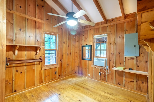 interior space with ceiling fan, cooling unit, hardwood / wood-style floors, electric panel, and lofted ceiling with beams