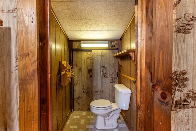 bathroom featuring a wall unit AC, toilet, and wood walls