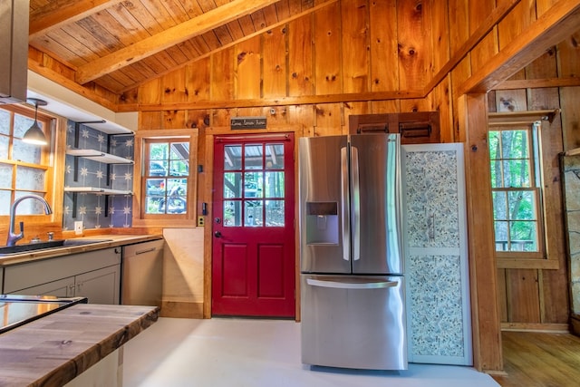 kitchen featuring sink, hanging light fixtures, vaulted ceiling with beams, stainless steel appliances, and wooden ceiling