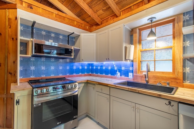 kitchen with sink, backsplash, stainless steel appliances, wood counters, and decorative light fixtures