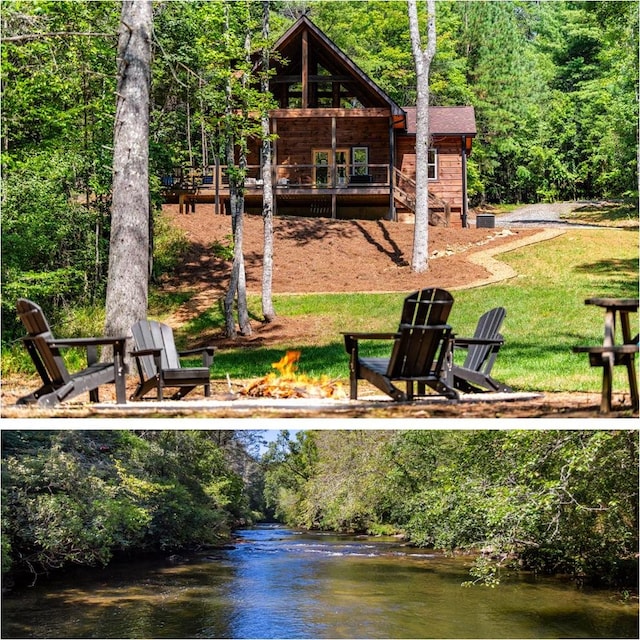 rear view of house featuring an outdoor fire pit, a water view, a yard, and a wooded view