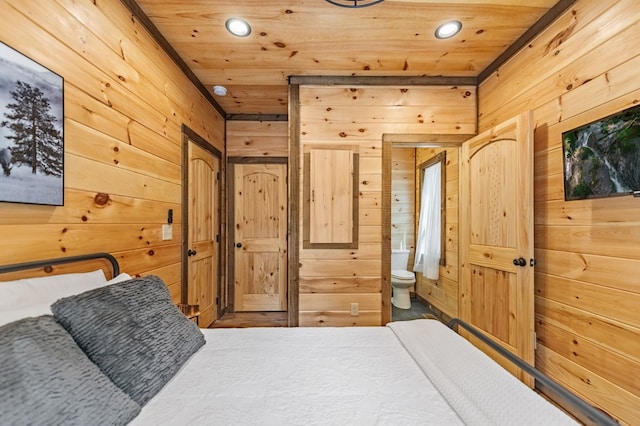 bedroom with ensuite bathroom, wood walls, and wood ceiling