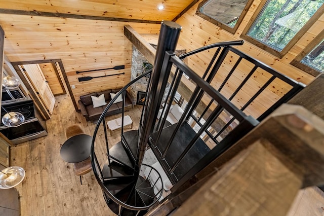 staircase with a towering ceiling, wood ceiling, and wooden walls