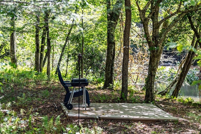 view of community with a forest view and a wooden deck