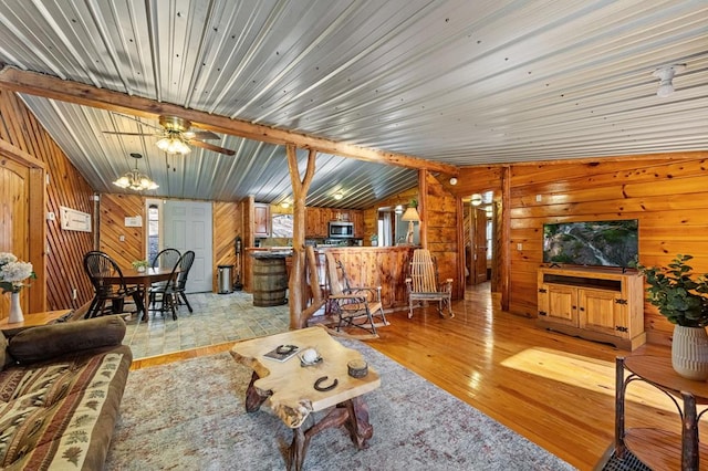 living room with wood walls, a notable chandelier, and light hardwood / wood-style flooring