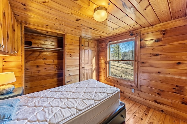 bedroom featuring hardwood / wood-style floors, wooden walls, and wooden ceiling