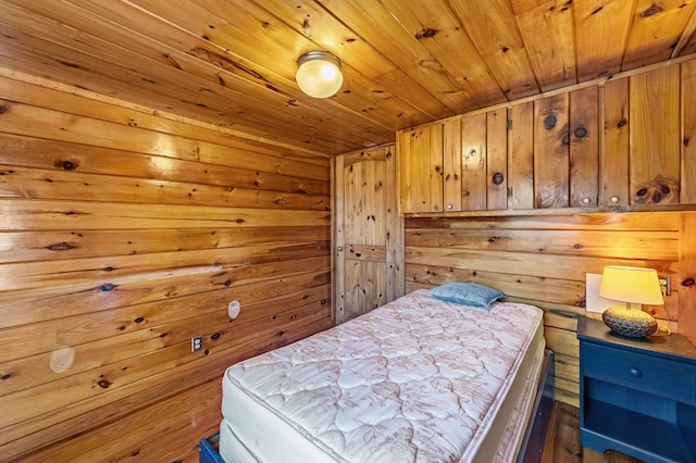 bedroom with wood ceiling and wood walls