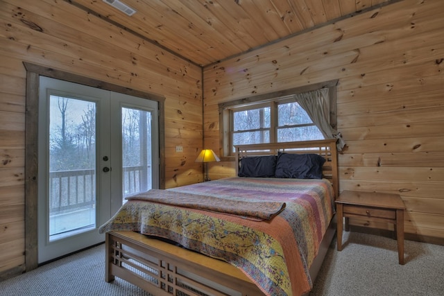 bedroom featuring access to exterior, french doors, carpet, wood ceiling, and wooden walls