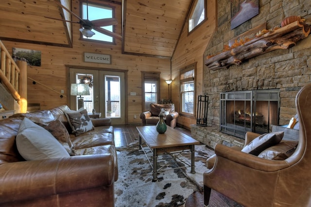 living room with french doors, hardwood / wood-style floors, a fireplace, and wood walls