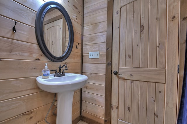 bathroom featuring wooden walls