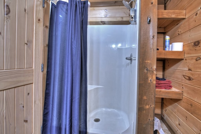 bathroom with walk in shower and wood walls