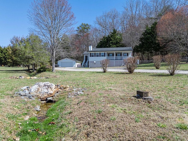 view of yard with a porch, an outdoor structure, and a detached garage