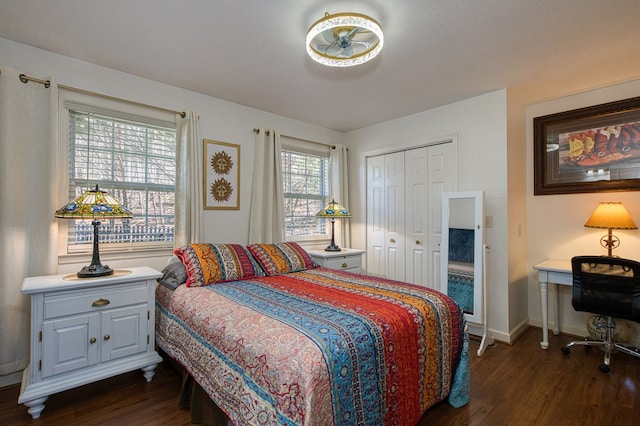 bedroom with baseboards, dark wood-style flooring, and a closet