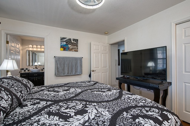 bedroom featuring a textured ceiling and ensuite bath