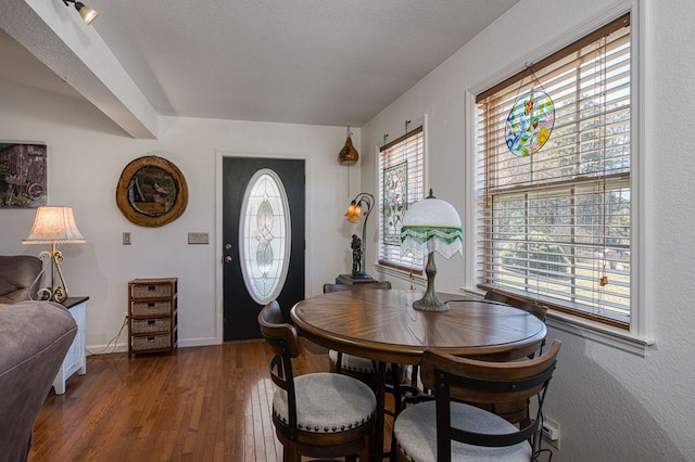 dining area with dark wood-style floors, a textured ceiling, and baseboards