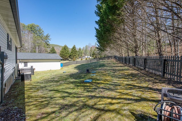 view of yard with central air condition unit and a fenced backyard