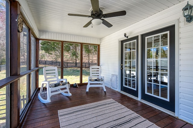 unfurnished sunroom with ceiling fan