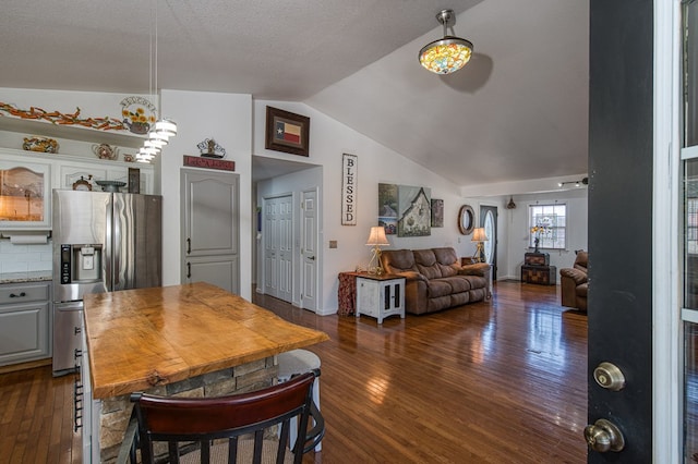 dining area with baseboards, dark wood-style flooring, and vaulted ceiling