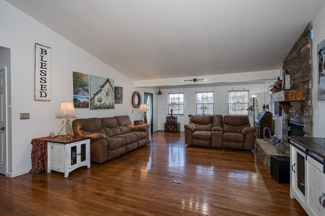 living area featuring a fireplace, vaulted ceiling, and hardwood / wood-style flooring