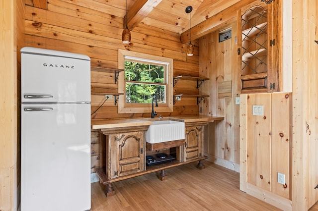 kitchen with pendant lighting, light wood-type flooring, wood ceiling, beamed ceiling, and white fridge