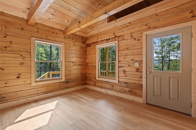 interior space featuring wooden walls, light wood-type flooring, and beam ceiling