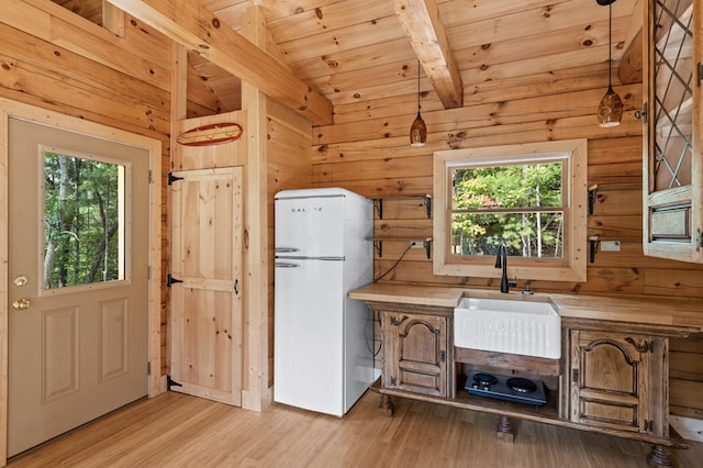 kitchen with pendant lighting, light wood-type flooring, white fridge, and a healthy amount of sunlight