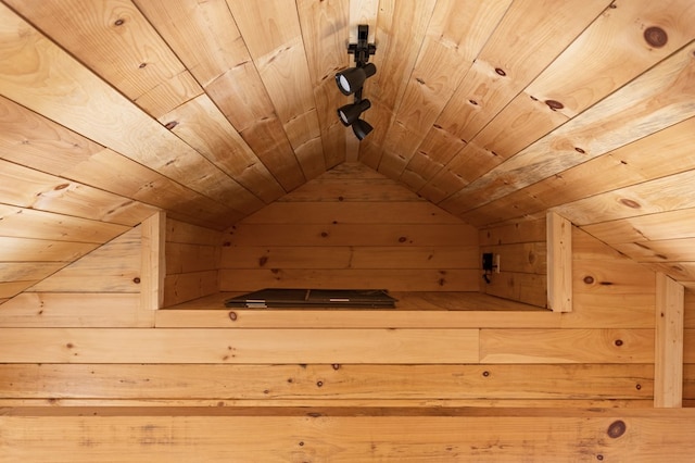 additional living space with wooden ceiling, lofted ceiling, and wooden walls