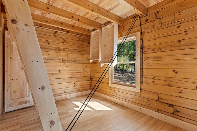 bonus room with wooden ceiling, beamed ceiling, wood walls, and light hardwood / wood-style flooring