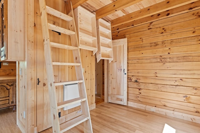 interior space with beamed ceiling, wooden walls, hardwood / wood-style floors, and wooden ceiling