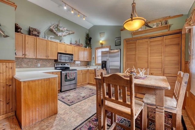 kitchen with stainless steel appliances, lofted ceiling, light countertops, decorative backsplash, and light brown cabinetry