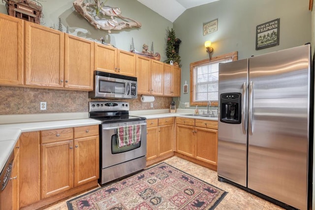 kitchen featuring lofted ceiling, backsplash, stainless steel appliances, and light countertops