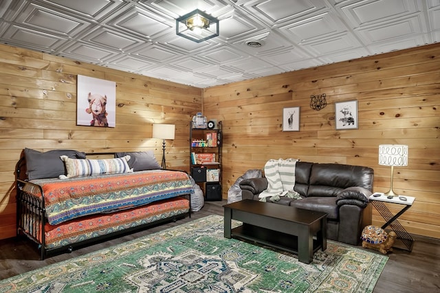 bedroom featuring wood finished floors, an ornate ceiling, and wooden walls