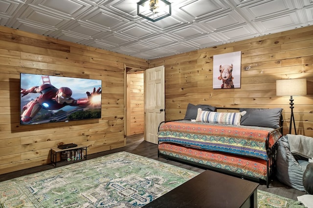 bedroom with wood finished floors, an ornate ceiling, and wooden walls