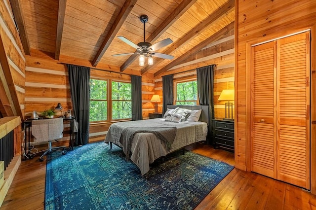 bedroom featuring hardwood / wood-style flooring, wood ceiling, ceiling fan, vaulted ceiling with beams, and wood walls