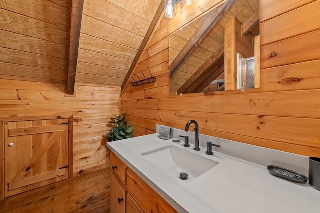 bathroom with wooden ceiling, vaulted ceiling, wooden walls, and vanity