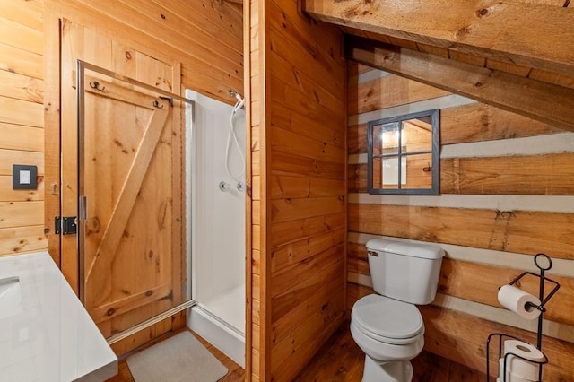 full bathroom featuring wood walls, a shower stall, and toilet