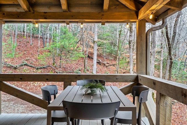 sunroom with beam ceiling and a view of trees