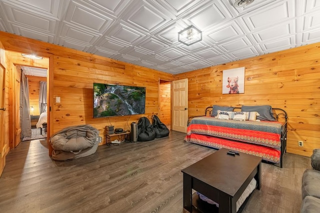 bedroom with wood walls, an ornate ceiling, and wood finished floors