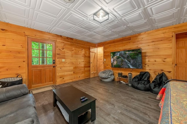 living room with an ornate ceiling, wooden walls, and wood finished floors