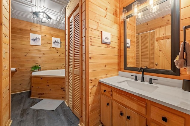 bathroom with a closet, wood finished floors, and wooden walls