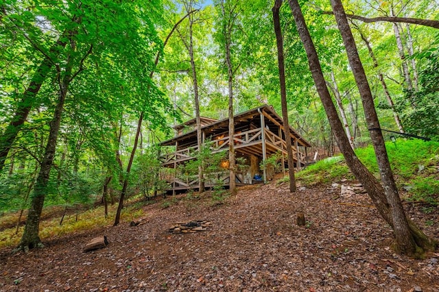 rear view of house featuring a deck and a view of trees