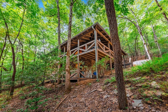 exterior space with a wooded view and a wooden deck