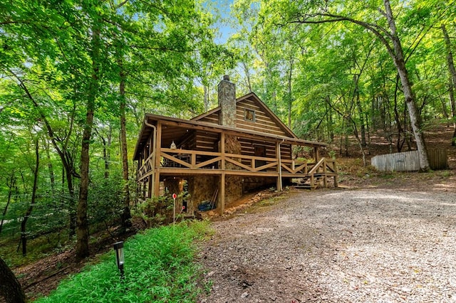 exterior space featuring a forest view and a chimney